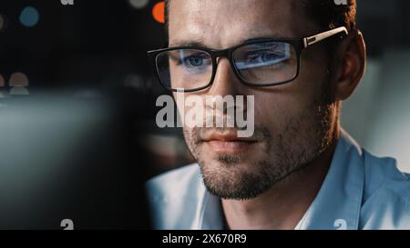Portrait of Male Startup Digital Entrepreneur Working on Computer, Line of Code Reflecting in Glasses. Developer Working on Innovative e-Commerce App using AI Algorithm Big Data. Stock Photo