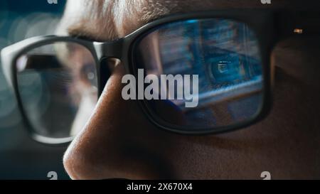 Close-up Portrait of Software Engineer Working on Computer, Line of Code Reflecting in Glasses. Developer Working on Innovative e-Commerce Application using Machine Learning, AI Algorithm, Big Data Stock Photo