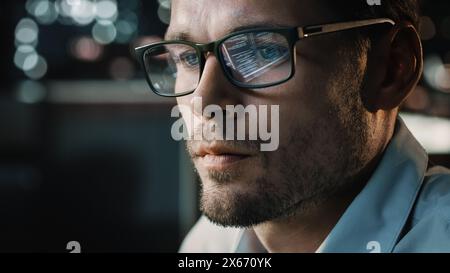 Portrait of Handsome Startup Digital Entrepreneur Working on Computer, Line of Code Reflecting in Glasses. Developer Working on Innovative e-Commerce Application using AI Algorithm to use Big Data Stock Photo
