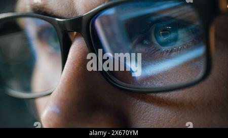 Close-up Portrait of Software Engineer Working on Computer, Line of Code Reflecting in Glasses. Developer Working on Innovative e-Commerce Application using Machine Learning, AI Algorithm, Big Data Stock Photo