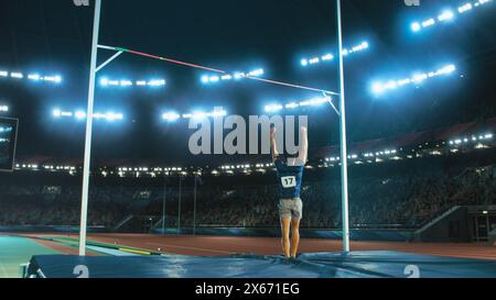 Shot of Professional Male Athlete Happily Celebrating New Record for Winning Sport Championship. Determined Successful Sportsman Raising Arms Cheering for Gold Medal Victory. Shot on Large Stadium Stock Photo