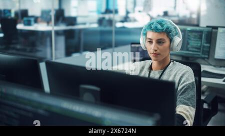 In Diverse Office: Portrait of Stylish Woman in Headphones Working on Desktop Computer. Modern Digital Entrepreneur Creating Colorful e-Commerce Project Design, e-Business Social Media Strategy Stock Photo