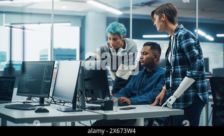 Team Meeting In Diverse Office: Project Manager with Disability points Prosthetic Arm at Computer Screen Talks with Multi-Ethnic Specialists. Software Engineers Collaborate on Creative Solution Stock Photo