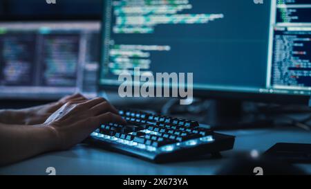Close-up Focus on Person's Hands Typing on the Desktop Computer Backlit Keyboard. Screens Show Coding Language User Interface. Software Engineer Create Innovative e-Commerce App. Program Development Stock Photo