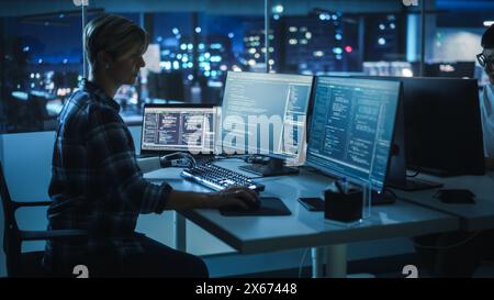 Night Office: Programmer With Disability Using Prosthetic Arm to Work on Computer Keyboard. Swift and Natural Use of Myoelectric Bionic Hand To Type Code for Software at Night. Stock Photo