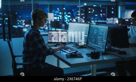 Night Office: Programmer With Disability Using Prosthetic Arm to Work on Illuminated Computer Keyboard at Night. Swift and Natural Use of Myoelectric Bionic Hand To Type Code for Software. Stock Photo