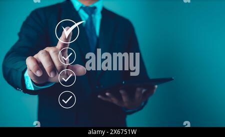 Businessman uses tablet to checklist and filling survey form online. Document management system, DMS. Quality control and accuracy Check. Stock Photo