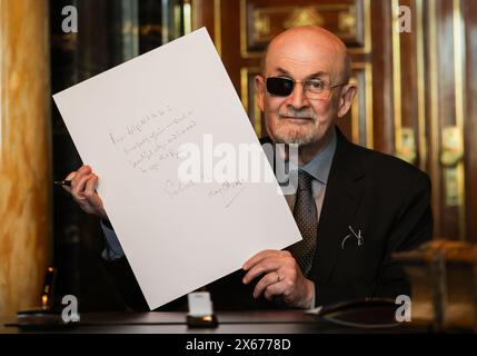 Hamburg, Germany. 13th May, 2024. The Indian-British writer Salman Rushdie shows his text after his entry in the city's Golden Book in the town hall. Credit: Christian Charisius/dpa/Alamy Live News Stock Photo