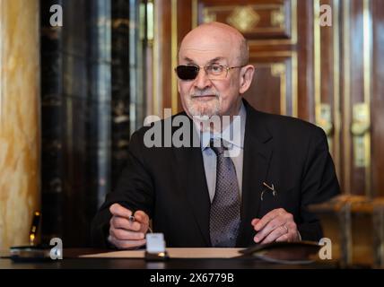 Hamburg, Germany. 13th May, 2024. The Indian-British writer Salman Rushdie signs the city's Golden Book in the town hall. Credit: Christian Charisius/dpa/Alamy Live News Stock Photo