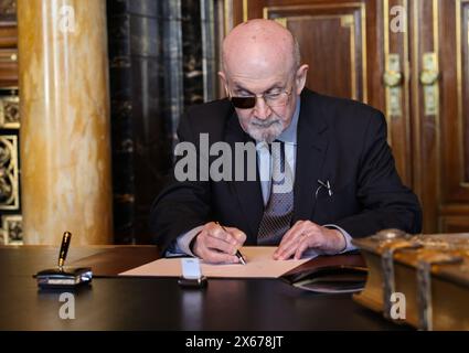 Hamburg, Germany. 13th May, 2024. The Indian-British writer Salman Rushdie signs the city's Golden Book in the town hall. Credit: Christian Charisius/dpa/Alamy Live News Stock Photo