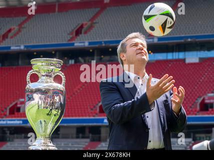 Munich, Germany. 13th May, 2024. Markus Söder (CSU), Minister President of Bavaria, throws a soccer into the air during the presentation of the European Football Championship trophy. Credit: Peter Kneffel/dpa/Alamy Live News Stock Photo