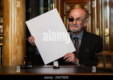 Hamburg, Germany. 13th May, 2024. The Indian-British writer Salman Rushdie shows his text after his entry in the city's Golden Book in the town hall. Credit: Christian Charisius/dpa/Alamy Live News Stock Photo