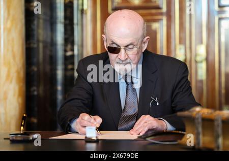 Hamburg, Germany. 13th May, 2024. The Indian-British writer Salman Rushdie signs the city's Golden Book in the town hall. Credit: Christian Charisius/dpa/Alamy Live News Stock Photo
