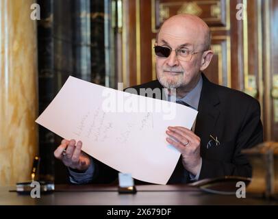 Hamburg, Germany. 13th May, 2024. The Indian-British writer Salman Rushdie shows his text after his entry in the city's Golden Book in the town hall. Credit: Christian Charisius/dpa/Alamy Live News Stock Photo