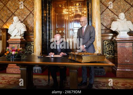 Hamburg, Germany. 13th May, 2024. The Indian-British writer Salman Rushdie (l) signs the city's Golden Book in the Town Hall alongside Peter Tschentscher (SPD), First Mayor of the Free and Hanseatic City of Hamburg and President of the Senate. Credit: Christian Charisius/dpa/Alamy Live News Stock Photo
