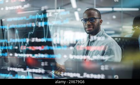 Real Office: Professional Black IT Programmer Working on Desktop Computer. Male Website Developer and Software Engineer Developing App, Video Game. Shot with Visual Effects of Running Code. Stock Photo