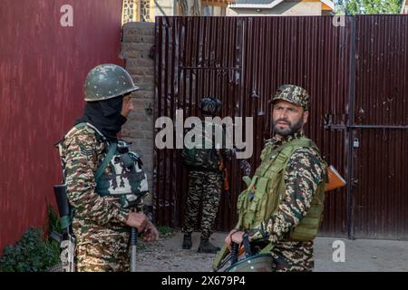 Srinagar, India. 13th May, 2024. Indian paramilitary trooper stands alert at a polling station during the fourth phase of the Lok Sabha, or lower house, of the Indian parliamentary elections in the outskirts of Srinagar. The 2024 Lok Sabha (lower house of Parliament) parliamentary elections mark the first major election in Jammu and Kashmir since New Delhi revoked Article 370, the region's special semi-autonomous status, in 2019. (Photo by Faisal Bashir/SOPA Images/Sipa USA) Credit: Sipa USA/Alamy Live News Stock Photo