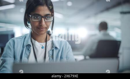 Diverse Office: Portrait of Beautiful Indian IT Programmer Working on Desktop Computer. Empowered Female Software Engineer Creating Innovative App, Program, Video Game in Friendly Environment Stock Photo