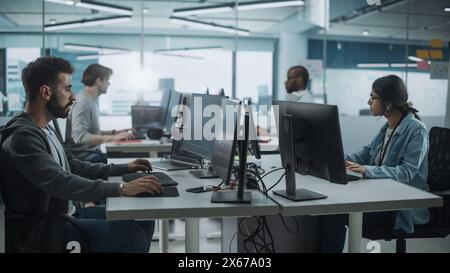 Diverse Multi-Ethnic Team Working in Big City Office: IT Programmers Working on Desktop Computers. Specialists Creating Innovative Software. Engineers Developing Inspiration App, Program. Stock Photo