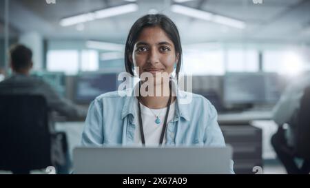 Diverse Office: Portrait of Beautiful Indian IT Programmer Working on Desktop Computer, Smiling and Looking at Camera Kindly. Female Software Engineer Creating Innovative App, Program, Video Game Stock Photo