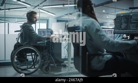 Disability-Friendly Office: Amazing IT Programmer with Disability in a Wheelchair Working on Desktop Computer. Male Specialist Create Inspirational Software. Engineer Develop Innovative App, Program Stock Photo