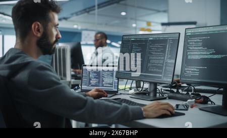 Diverse Office: Enthusiastic White IT Programmer Working on Desktop Computer. Male Specialist Creating Innovative Software. Engineer Developing App, Program, Video Game. Writing Code in Terminal Stock Photo