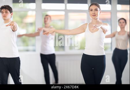 Experienced young female ballet dancer, dressed in white top and black leggings Stock Photo