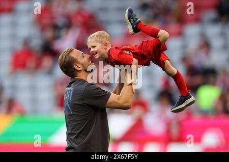 MUNICH, GERMANY - MAY 12: Harry Kane of Bayern Munich interacts with his son Louis Kane after the Bundesliga match between FC Bayern München and VfL Wolfsburg at Allianz Arena on May 12, 2024 in Munich, Germany. © diebilderwelt / Alamy Stock Stock Photo