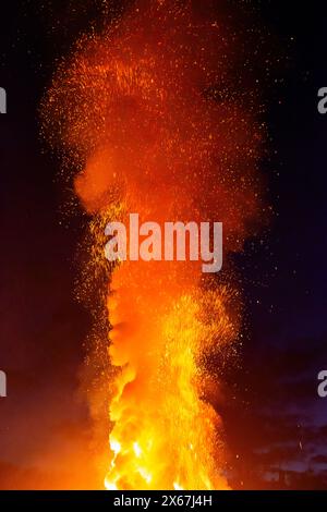Column of smoke and glittering sparks from a fire against a black background Stock Photo