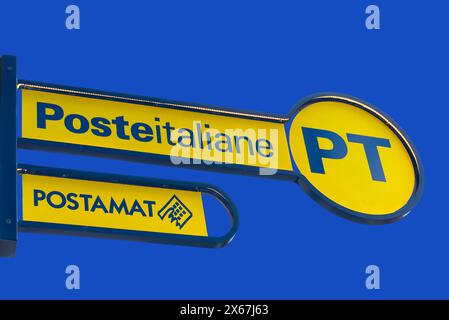 Italy - May 09, 2024: PT Poste Italiane, Italy Post logo and Postman logo on yellow sign on blue sky, outside the Italian post office. Tex: Posteitali Stock Photo
