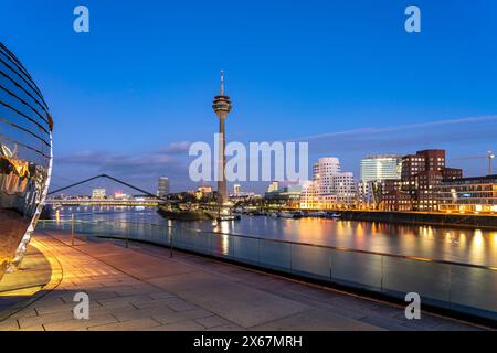 View from the terrace of the Hyatt Hotel of the Gehry buildings - Neuer Zollhof at the Medienhafen and the Rhine Tower in Düsseldorf at dusk, North Rhine-Westphalia, Germany Stock Photo