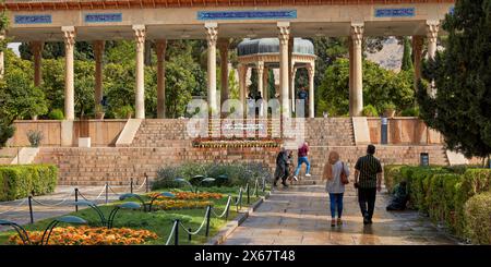 People walk in the landscaped garden at the Tomb of Hafez, one of the greatest Persian poets of all times. Shiraz, Iran. Stock Photo