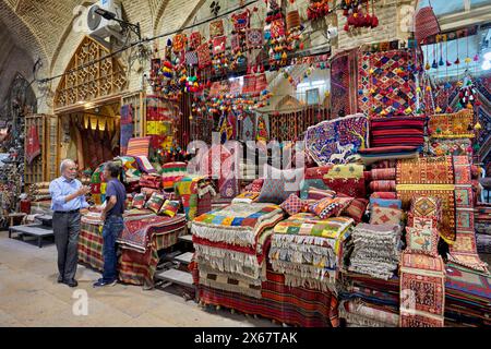 Two Iranian men talk at a handicraft shop in the Vakil Bazaar. Shiraz, Iran. Stock Photo