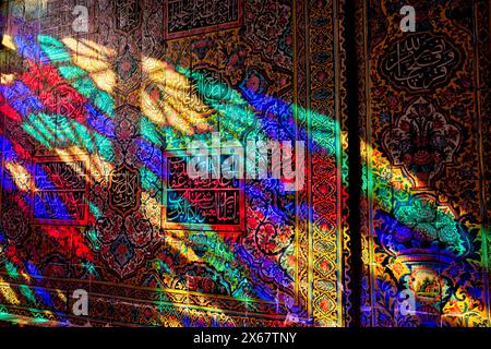 A play of light from multi-colored stained-glass windows inside the 19th century Nasir al-Mulk Mosque, aka the Pink Mosque. Shiraz, Iran. Stock Photo