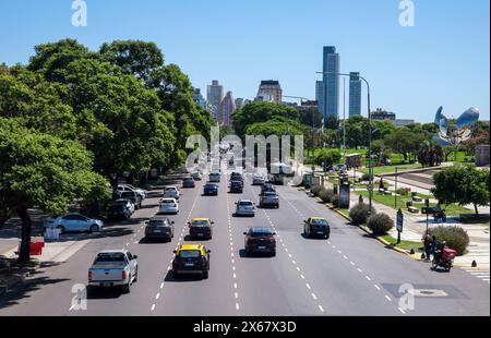 Buenos Aires, Argentina, city traffic on Av. Pres. Figueroa Alcorta, one-way street with 6 lanes in the city district of Recoleta. On the right in the park is the Floralis Generica attraction. Floralis Generica is a sculpture made of steel and aluminum in the Plaza de las Naciones Unidas, Avenida Figueroa Alcorta, Buenos Aires, a gift to the city from the Argentine architect Eduardo Catalano. Stock Photo