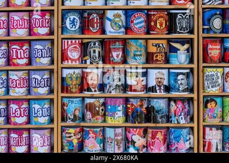 Selection of brightly coloured mugs for sale on the streets of Belgrade. With football teams and famous people like Nikola Tesla and Putin. April 2024 Stock Photo