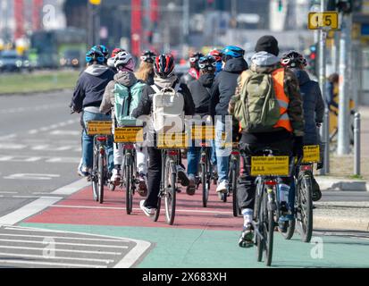 Berlin, Germany. 31st Mar, 2024. A group of cyclists is riding in the city center on the bike path that is marked off from the road by a different color. Credit: Soeren Stache/dpa/Alamy Live News Stock Photo