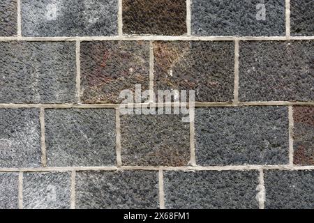 Fragment of a gray stone block wall for use as an abstract background and textures. Stock Photo