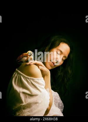 woman in romantic attitude with a chick on her shoulder, spain Stock Photo