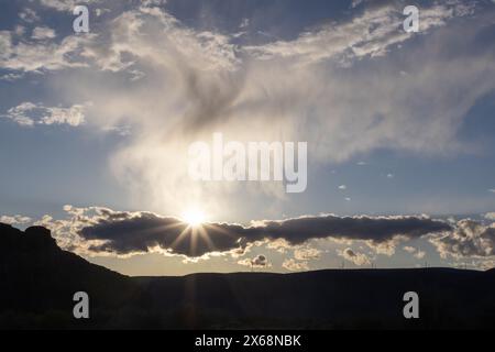Afternoon sun rays break through clouds Stock Photo