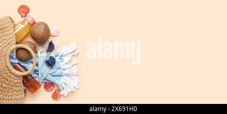 Wicker bag with beach accessories on beige background with space for text Stock Photo