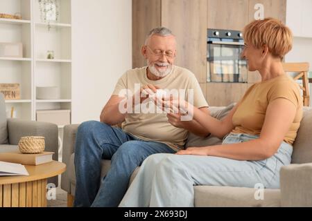 Mature man giving pills to his sick wife at home Stock Photo
