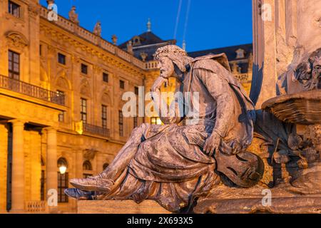 Statue of the poet Walther von der Vogelweide at the Frankoniabrunnen in front of the Residenz at dusk, Würzburg, Bavaria, Germany Stock Photo