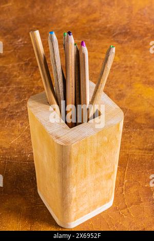 Wooden pencil container, close-up of a wooden container with colored pencils Stock Photo