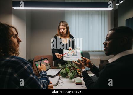 Multicultural team discussing growth statistics in modern office setting Stock Photo