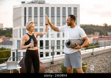 Happy sports couple giving each other high five after completing sports workout. Stock Photo