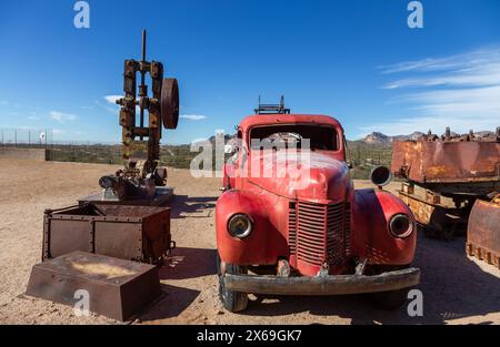 Vintage Old Red Truck and Abandoned Rusty Mining Site Equipment Machinery Relic.  Historic Goldfield Wild West Ghost Town Apache Junction Arizona USA Stock Photo