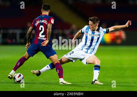 Barcelona, Spain. 13th May, 2024. Turrientes (Real Sociedad) duels for the ball against Joao Cancelo (FC Barcelona) during La Liga football match between FC Barcelona and Real Sociedad, at Lluis Companys Stadium in Barcelona, Spain, on May 13, 2024. Foto: Siu Wu. Credit: dpa/Alamy Live News Stock Photo