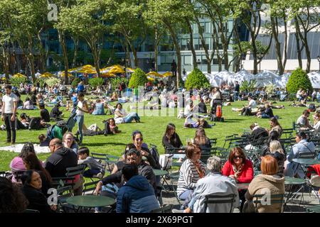 Tourists and New Yorkers enjoy the urban oasis Bryant Park  in Midtown Manhattan on a sunny spring day, 2024, New York City, United States Stock Photo