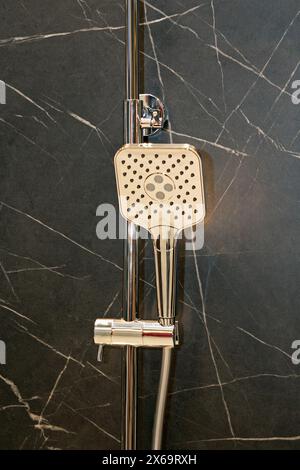 Modern shower faucet hanging on a bathroom wall Stock Photo